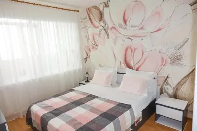 a bedroom with a bed with a flower mural on the wall at Magnolia in Burgas City