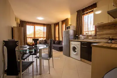 a kitchen and living room with a table in a kitchen at Kalia apartment in Sunny Beach