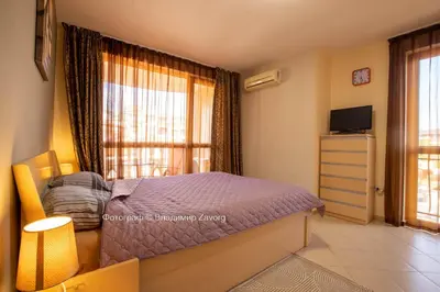 a bedroom with a bed and a tv and a window at Kalia apartment in Sunny Beach