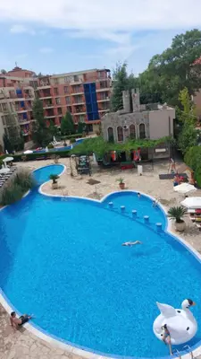 a large blue swimming pool with buildings in the background at Kalia apartment in Sunny Beach