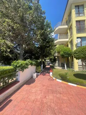 a red brick walkway in front of a building at Aurelia Residences in Ravda