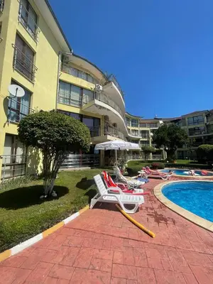 a resort with chairs and a pool and a building at Aurelia Residences in Ravda