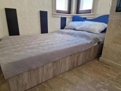 a large bed with a wooden frame in a room at Słoneczny Brzeg Studio Amara in Sunny Beach