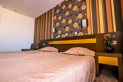 a bedroom with two beds and a vase of flowers at Izola Paradise Hotel - All Inclusive in Sunny Beach