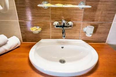 a white sink in a bathroom with a wooden counter at Izola Paradise Hotel - All Inclusive in Sunny Beach