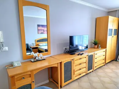 a room with a wooden desk with a tv and a mirror at Marina Hills in Sozopol