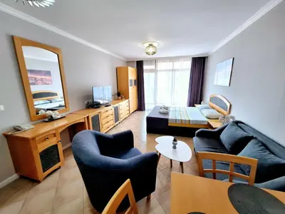 a living room with a blue couch and a table at Marina Hills in Sozopol