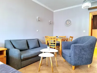 a living room with two blue couches and a table at Marina Hills in Sozopol