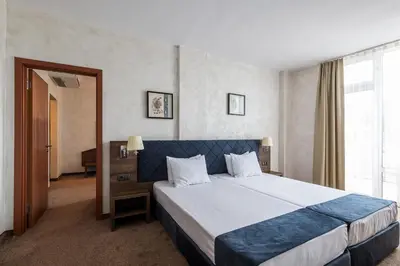 a bedroom with a large bed and a large window at Flamingo Beach Hotel in Sunny Beach