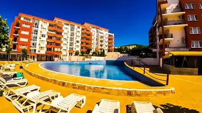 a large swimming pool with lounge chairs and buildings at William's apartments - sixth large apartment in Sveti Vlas