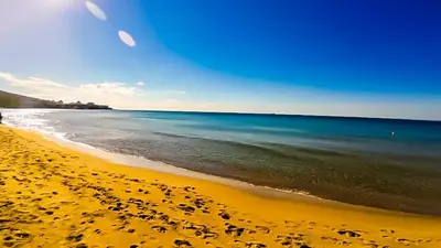 a beach with a yellow sand and the ocean at William's apartments - sixth large apartment in Sveti Vlas