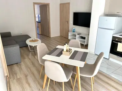 a living room with a dining room table and chairs at AVRORA SUITE in Varna City