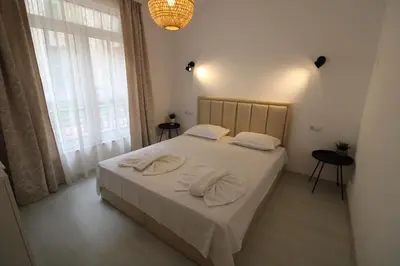 a bedroom with a bed with two towels on it at Flores Garden - Menada Apartments in Chernomorets
