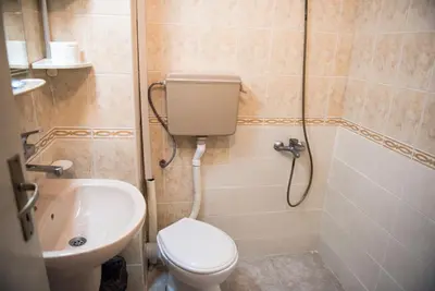 a bathroom with a toilet and a sink at Hotel Relax in Varna City