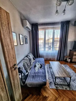 a room with a bed and a table in it at Sea Light in Burgas City