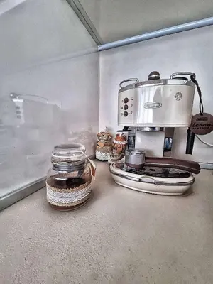 a kitchen with a coffee maker and jars on a counter at Sea Light in Burgas City