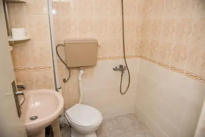 a bathroom with a toilet and a shower and a sink at Стаи за гости in Varna City