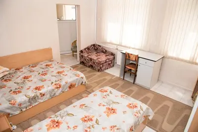 a small bedroom with two beds and a desk at Стаи за гости in Varna City