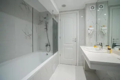 a white bathroom with a tub and a sink at Perla Royal Hotel - All Inclusive in Primorsko