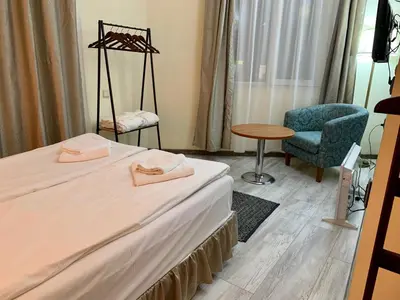 a hotel room with two beds and a chair at Guest Rooms Donovi in Varna City