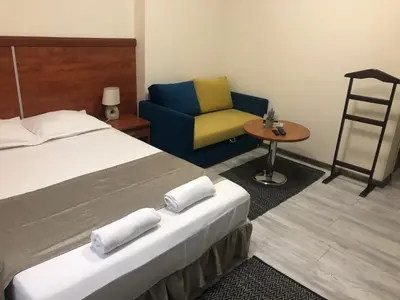 a hotel room with a bed and a chair at Guest Rooms Donovi in Varna City