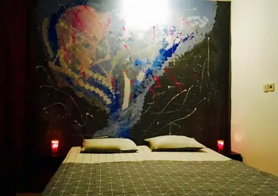 a bedroom with a bed with a painting on the wall at Zapovedni Rai in Primorsko