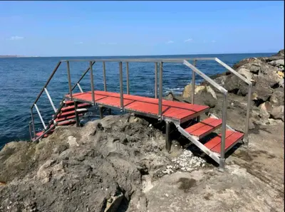 a red platform on the rocks near the ocean at Sozopol Созопол- SOZOPOLIS -MORE SUN 2А- in Sozopol