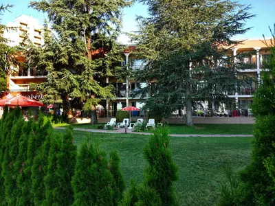 a park with chairs and trees in front of a building at Elizabeth Dy Boutique Hotel in Nesebar