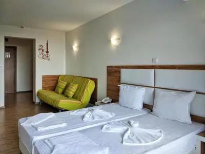 a bedroom with a bed and a green couch at Elizabeth Dy Boutique Hotel in Nesebar