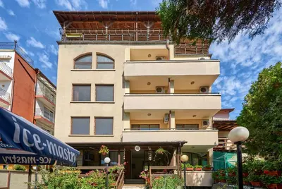 a tall building with a sign in front of it at Hotel Koral in Primorsko
