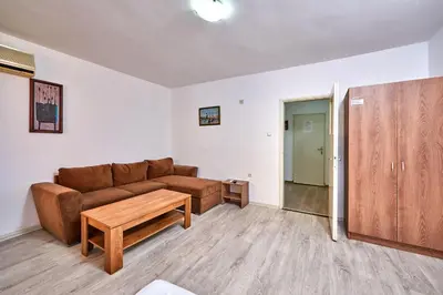 a living room with a brown couch and a table at Hotel Koral in Primorsko