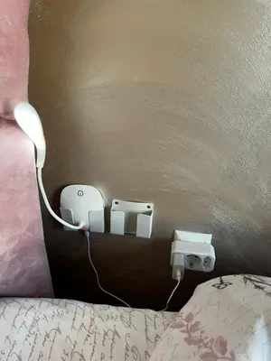 a bed with a light plugged into a wall at Varna downtown apartment in Varna City