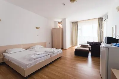 a bedroom with a bed and a living room at Plovdiv Hotel in Primorsko