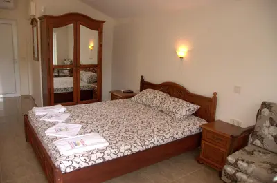 a bedroom with a bed with a mirror and a chair at Camping Goldfish in Sozopol