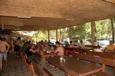 a group of people sitting at tables in a restaurant at Camping Goldfish in Sozopol
