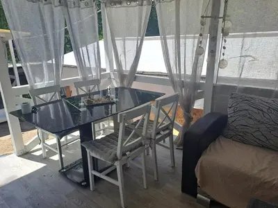 a glass table with two chairs and a bed at Camping Goldfish in Sozopol