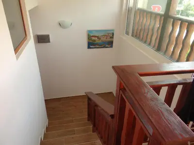 a stairway with a wooden bench and a window at Guest House Rosa in Kiten