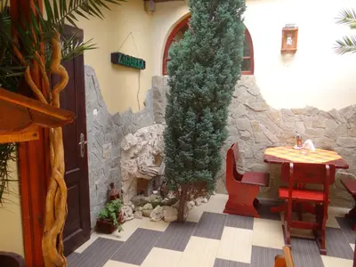 a restaurant with a table and a tree in a room at Guest House Rosa in Kiten