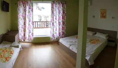 two beds in a room with a window at Guest House Rosa in Kiten