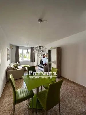a living room with a table and green chairs at Aparthotel Rutland bay in Ravda