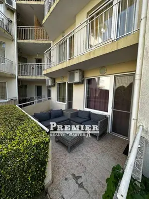 a patio in front of a building with a couch at Aparthotel Rutland bay in Ravda