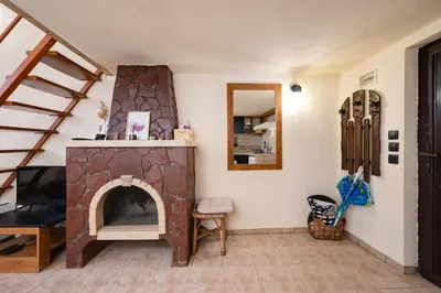 a living room with a stone fireplace and a staircase at Cozy Nest Charming Loft in the heart of Varna in Varna City