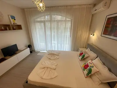a living room with a couch and a large window at Menada Royal Dreams Apartments in Sunny Beach