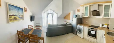 a kitchen and living room with a table and a couch at Apolonia Apartments - Boutique Family Residence in Sozopol