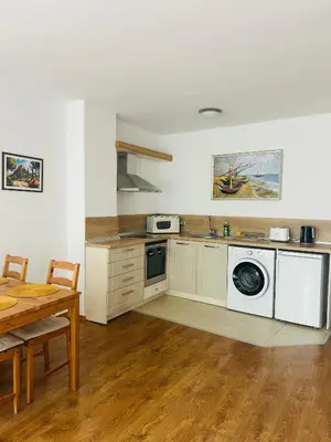 a kitchen with white appliances and a wooden table at Apolonia Apartments - Boutique Family Residence in Sozopol