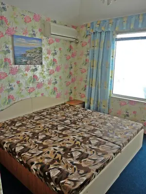 a bedroom with a large bed with floral wallpaper at Guest Rooms Casa Luba in Sveti Vlas