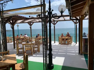 a restaurant with the ocean in the background at Elizabeth Beach Apartments in Nesebar