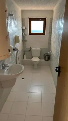 a bathroom with a white toilet and a sink at Elizabeth Beach Apartments in Nesebar