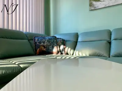 a living room with a couch with a blanket on it at NJ Luxury rooms and suites in Varna City
