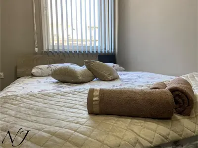 a bed with pillows on top of it in a bedroom at NJ Luxury rooms and suites in Varna City